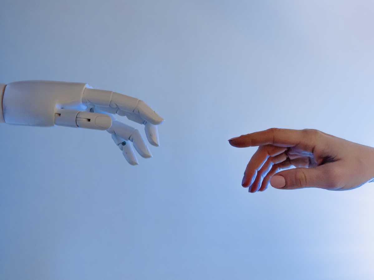 A robot and a human hand reaching towards each other