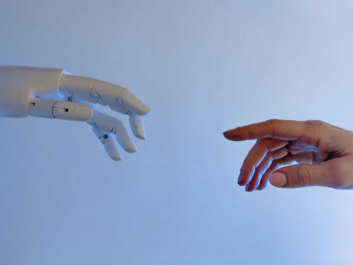 A robot and a human hand reaching towards each other