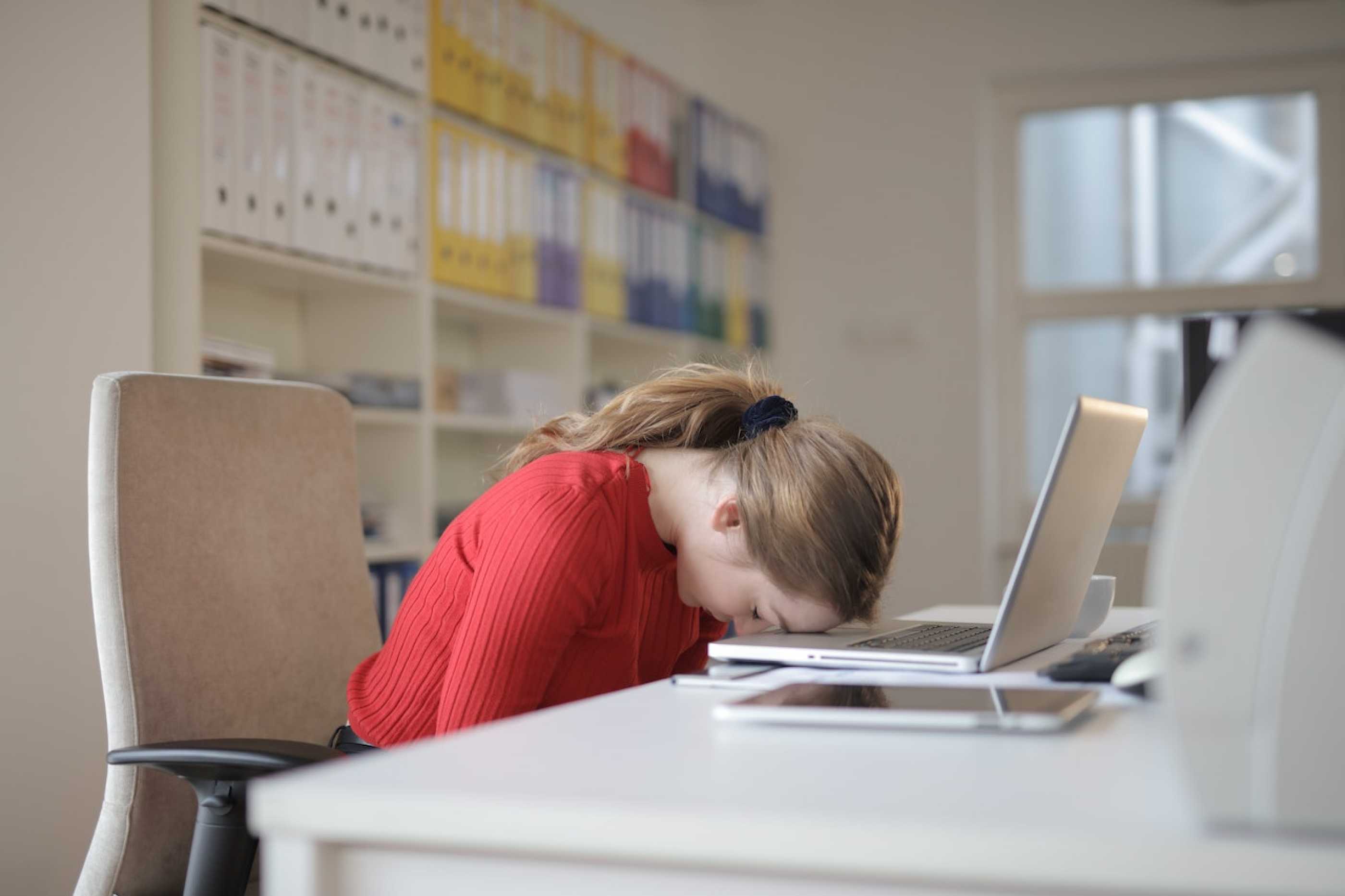 Woman asleep on her computer keyboard